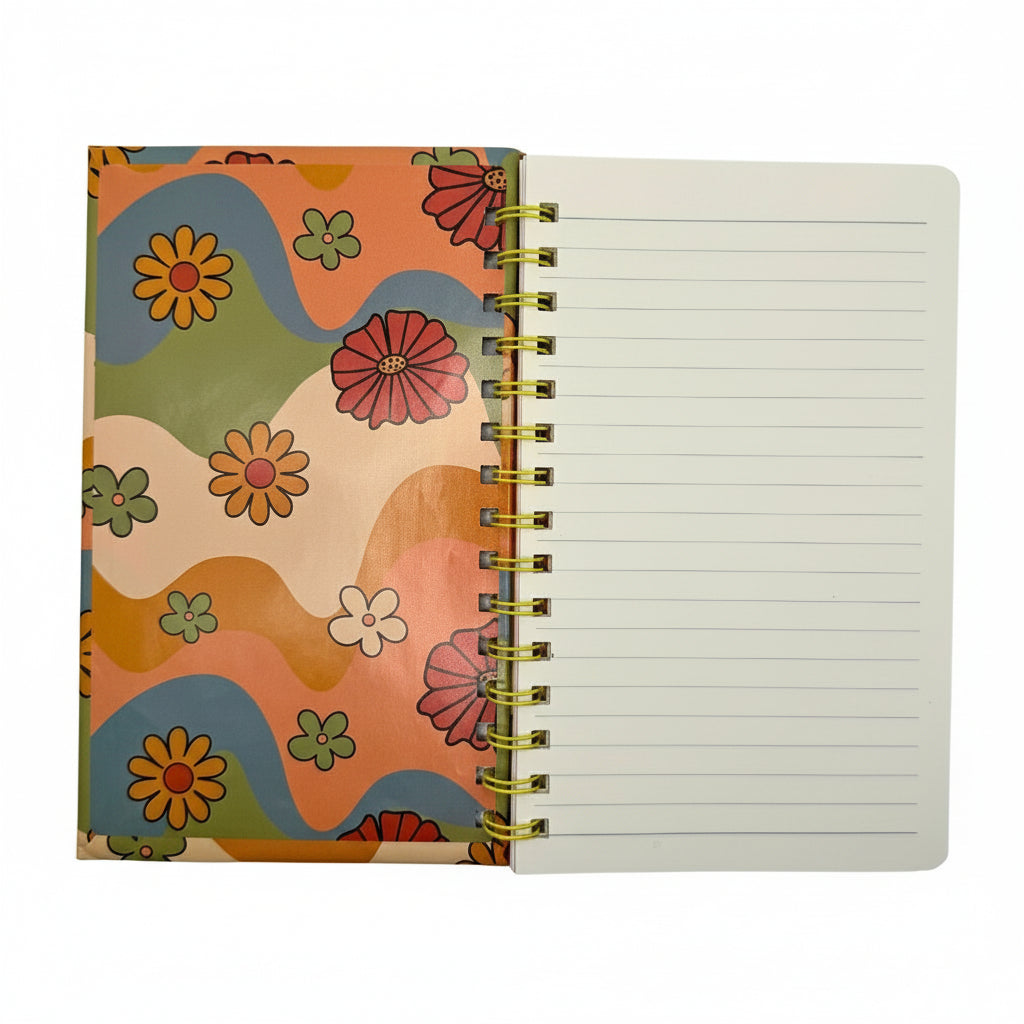 Notebook with colorful floral cover and open to reveal lined pages on a white background
