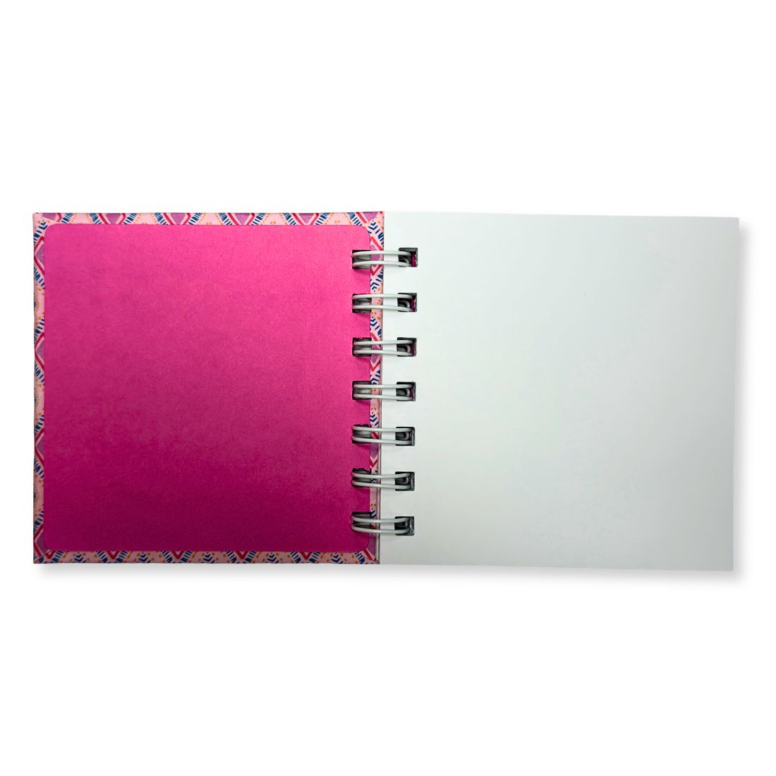Open notebook with pink inside cover and white pages on a white background