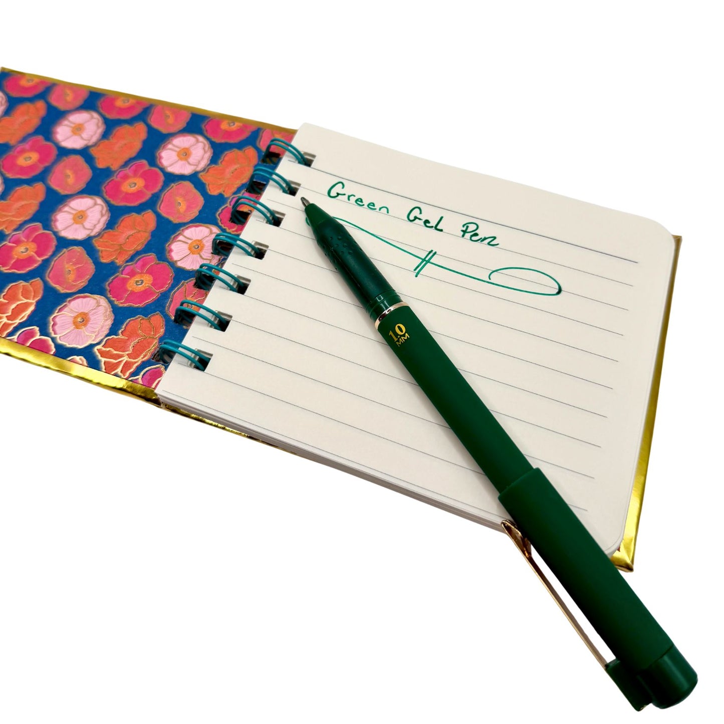 Green gel pen on an open notebook with floral cover