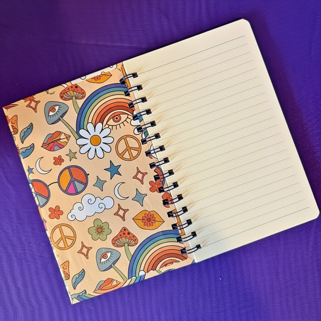 Notebook with a colorful pattern on the cover and a blue pen on a purple background