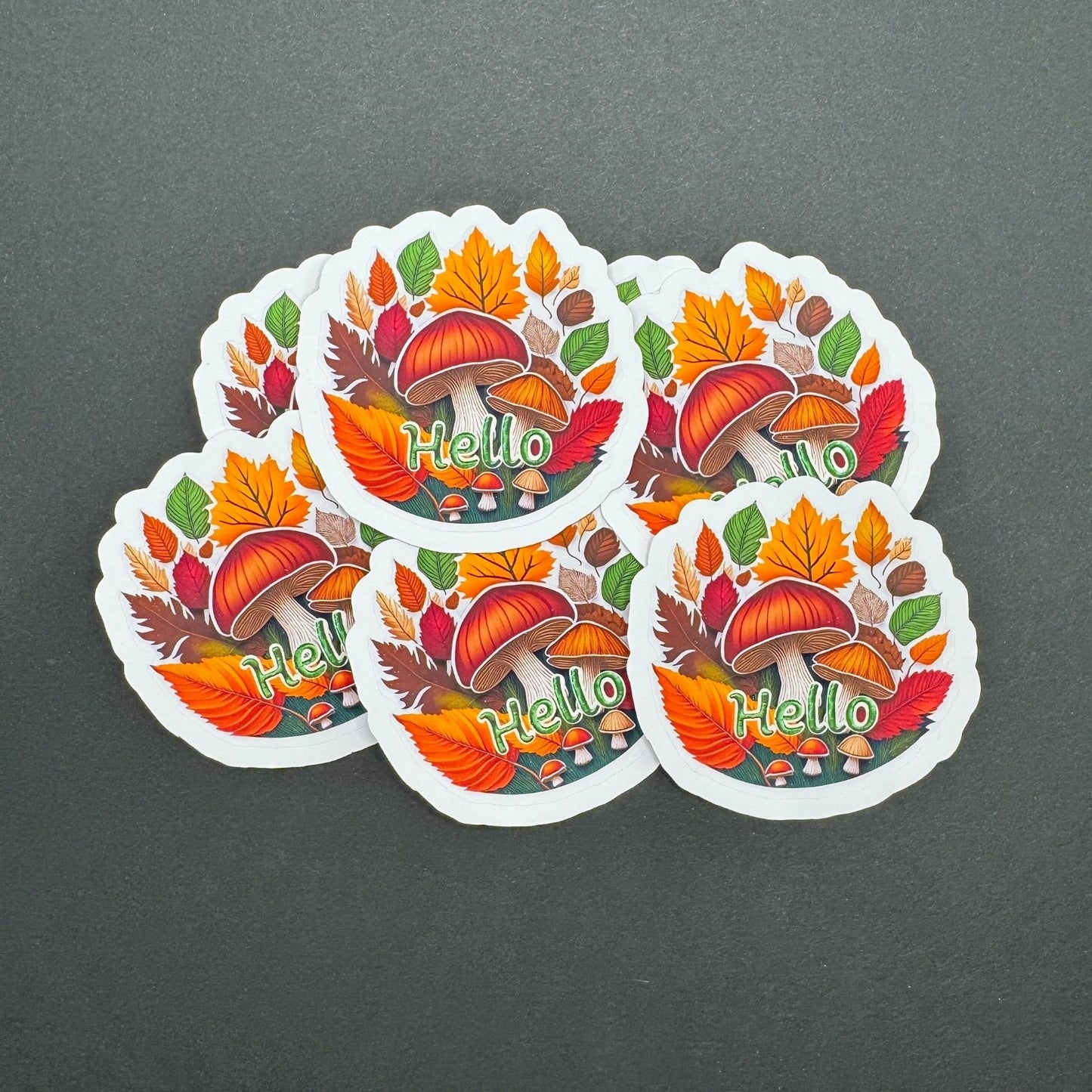 Five colorful stickers with autumn-themed design and 'Hello' text on a gray background