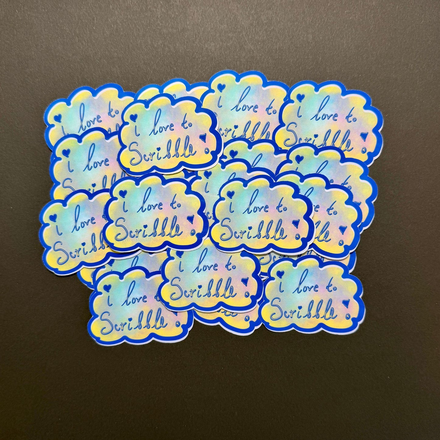 Holographic stickers with 'I love to Swiddle' text on a brown background