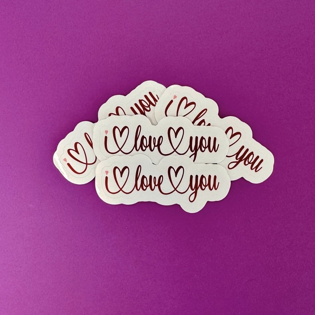 Multiple 'I love you' stickers on a purple background