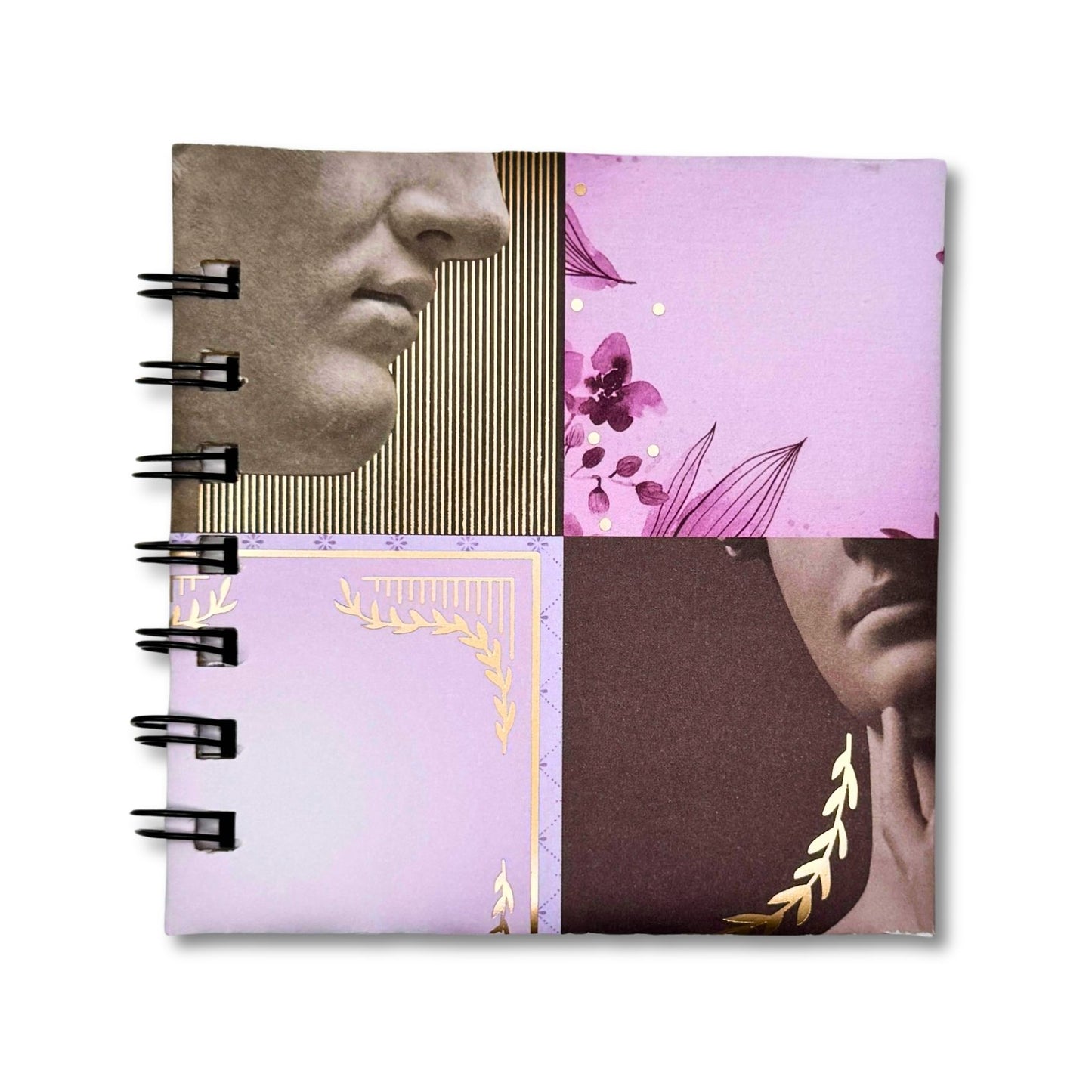 Notebook with artistic cover design featuring faces and floral elements on a white background