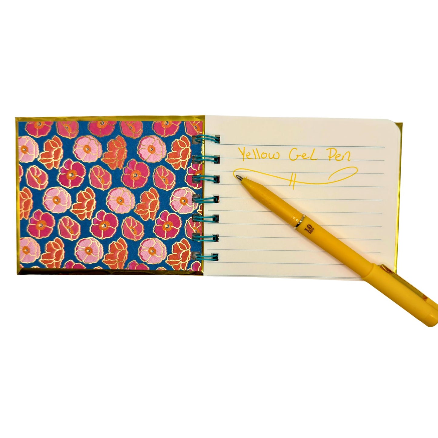 Notebook with floral cover and yellow pen on a white background